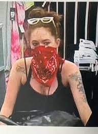 Store camera still of a person wearing a red bandana, with white sunglasses on her head