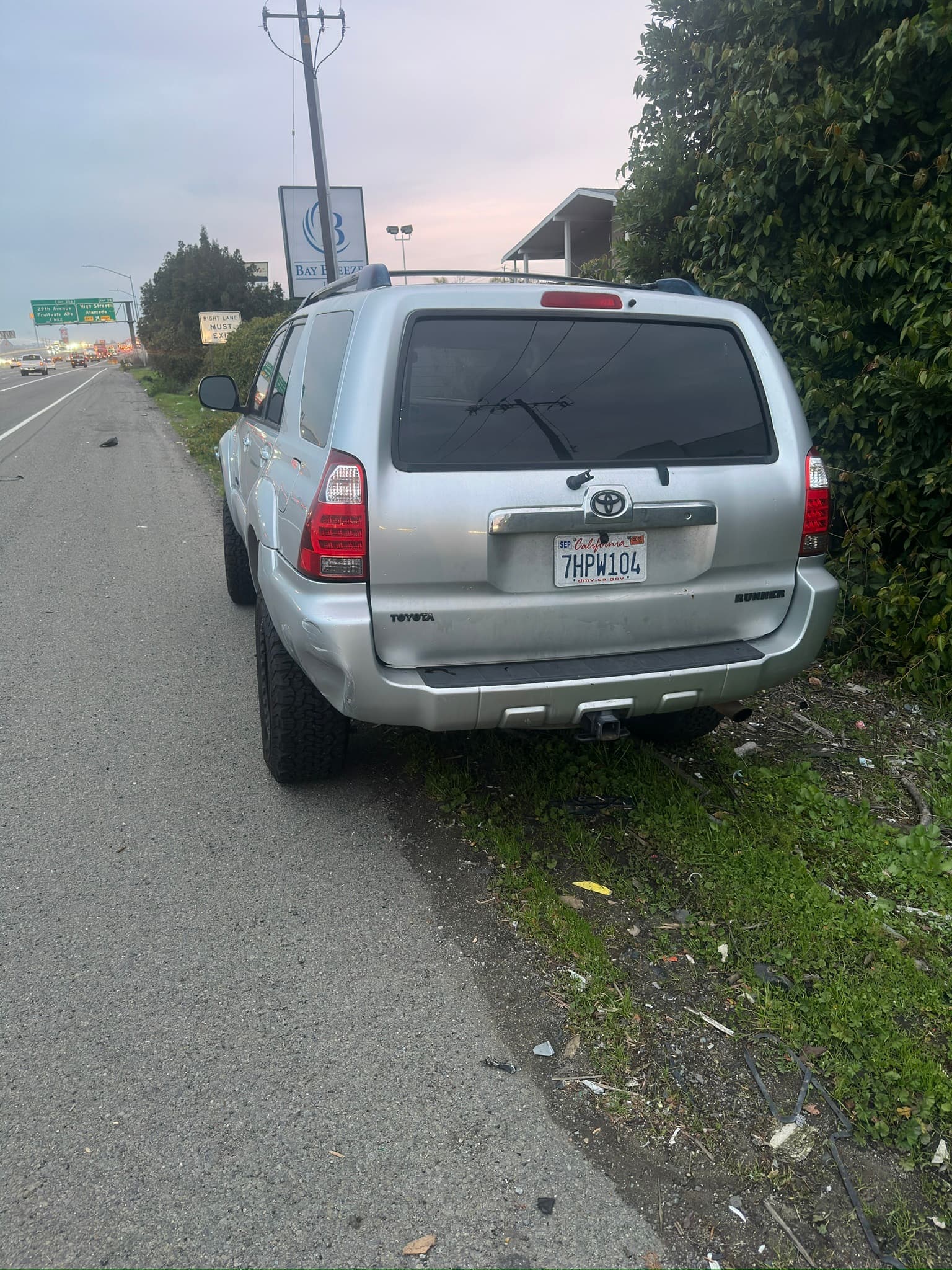 Rear view of a silver Toyota 4Runner parked beside a road